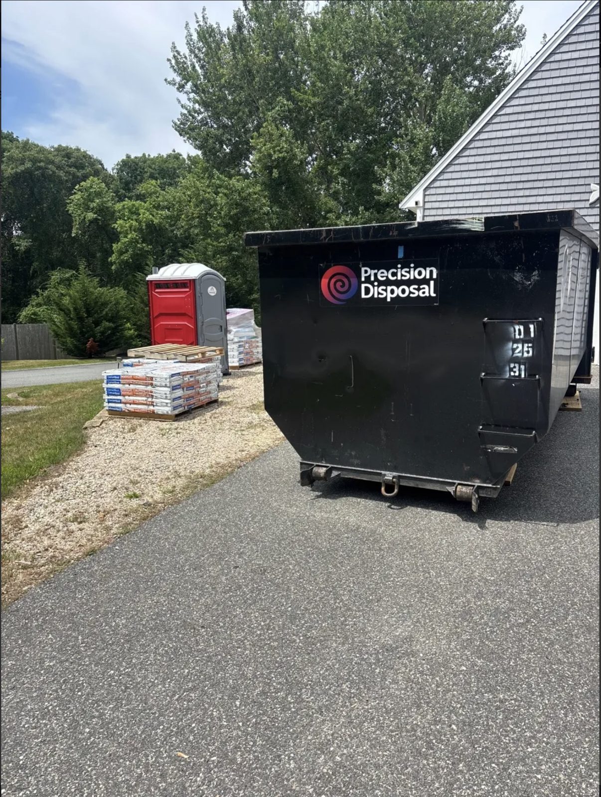 Precision Disposal roll-off dumpster at a residential job site