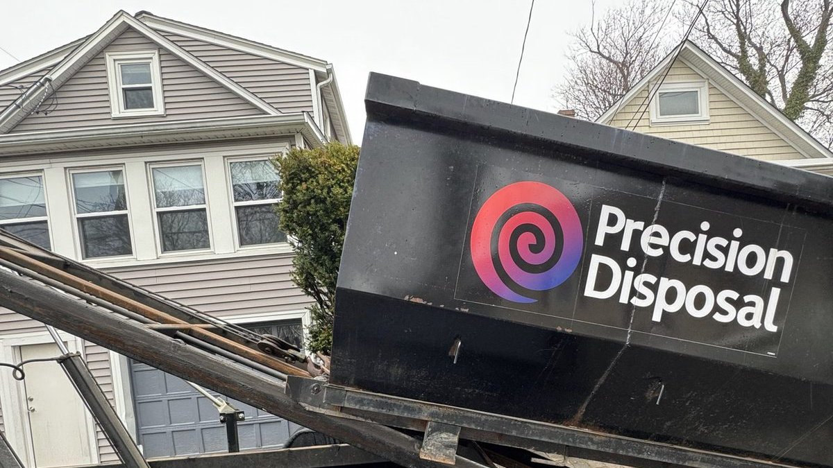 Precision Disposal dumpster on a trailer at a home