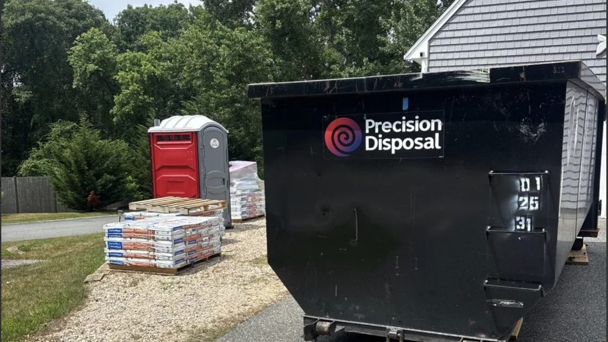 Precision Disposal roll-off dumpster at a residential job site